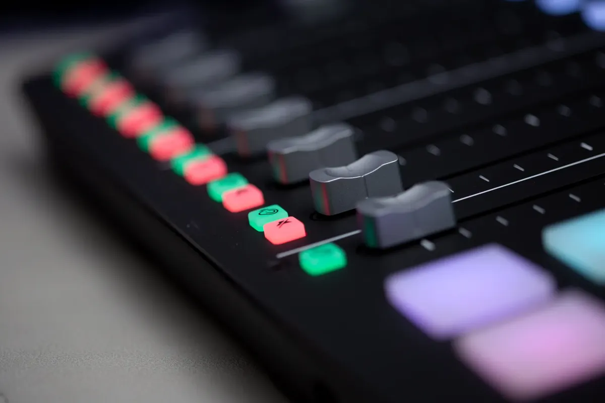 Detailed close-up of a professional sound mixer with colorful buttons and sliders.